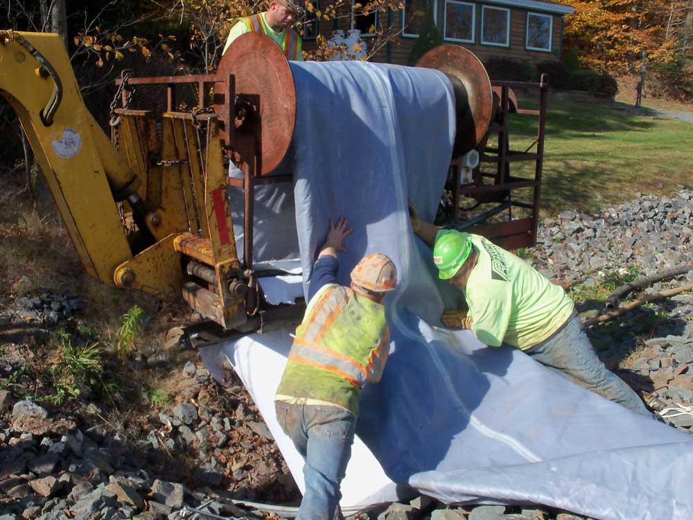 2 Construction workers with blue tarp at construction zone