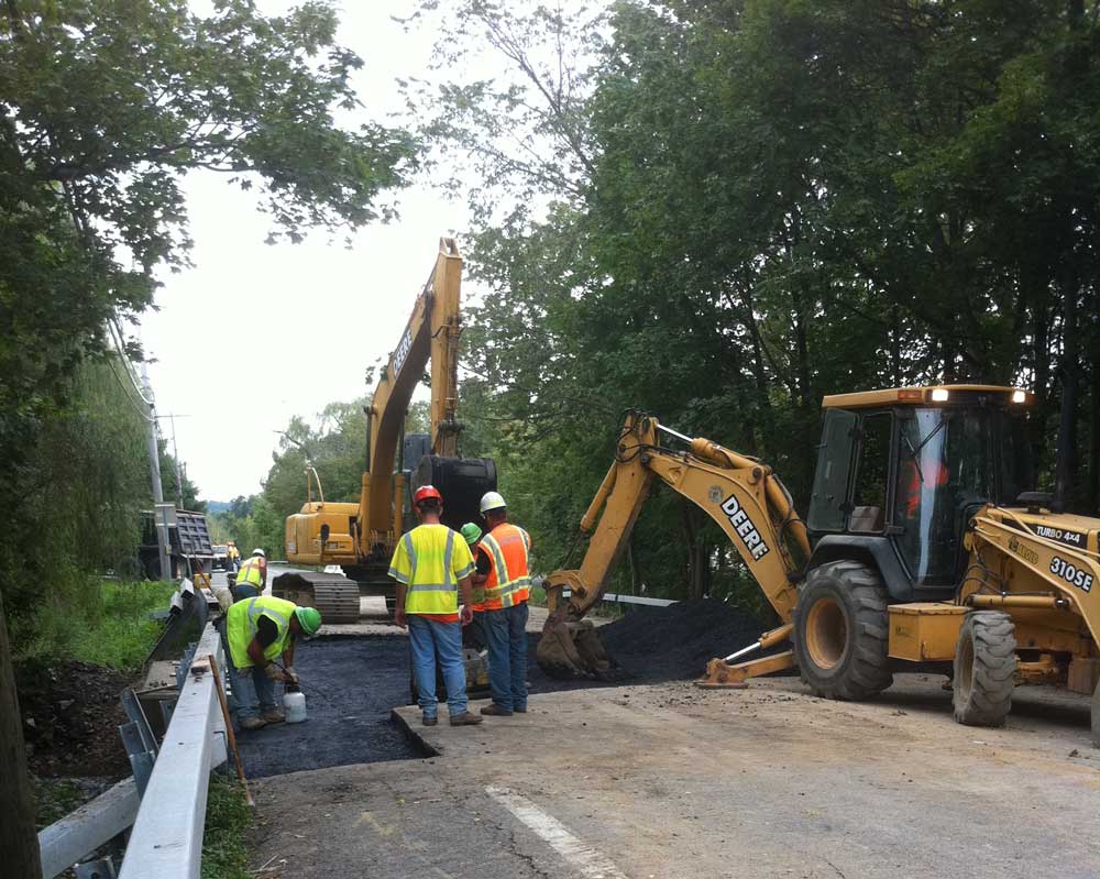 Construction workers with construction equipment working on road