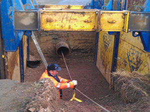 Construction worker in hole in ground working on wiring