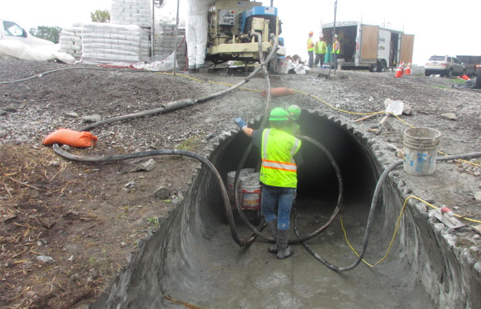 Construction worker standing inside of large pipe entrance